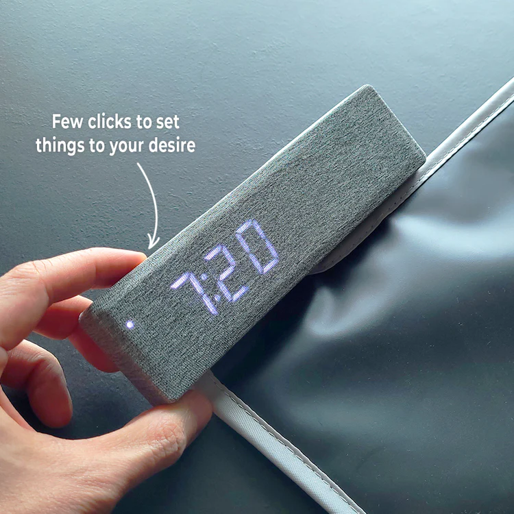 A hand holding Ruggie 2.0, its soft display reading 7:20 while you set it